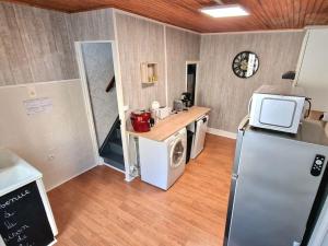 una cocina con nevera y lavadora en La Maison De Nelly labellisé 3*, en Mouzon