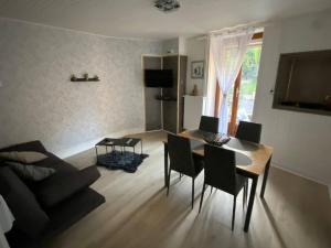 een woonkamer met een tafel en stoelen en een bank bij La Maison De Nelly labellisé 3* in Mouzon