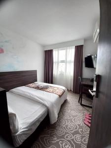 a hotel room with two beds and a desk at Gateway To Kota Samarahan education hub Sama Jaya ind centre classic 30BR by Natol Traveller & Business Inn in Kuching