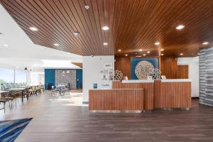 a lobby with a wooden ceiling and tables and chairs at Fairfield by Marriott Inn & Suites San Francisco Pacifica in Pacifica