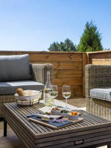 uma mesa com copos de vinho e comida num pátio em Domitia Roussillon Appartement Luberon em Roussillon