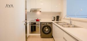 a kitchen with a washing machine and a sink at AYA Boutique - Beach View in this 1BR Apartment in Dubai Marina in Dubai