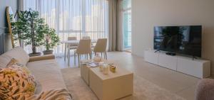 a living room with a couch and a tv and a table at AYA Boutique - Beach View in this 1BR Apartment in Dubai Marina in Dubai