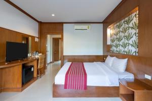 ein Hotelzimmer mit einem Bett und einem Flachbild-TV in der Unterkunft Maleedee Bay Resort in Ao Nang Beach