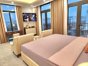 um quarto com uma cama grande, cadeiras e janelas em Sakura Homestay Cao cấp T4 em Gia Lâm Pho
