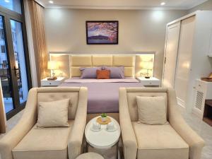um quarto com uma cama, 2 cadeiras e uma mesa em Sakura Homestay Cao cấp T4 em Gia Lâm Pho
