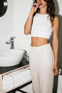 a woman brushing her teeth in a bathroom at Riders Hotel in Laax