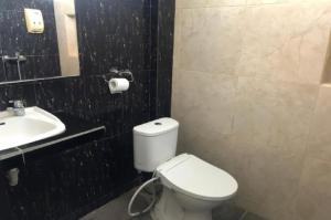een badkamer met een wit toilet en een wastafel bij TwoSpaces Living at D'Rainbow Homestay in Mergoredjo