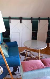 a living room with a table and a couch at Gîte L'Escalier des Rêves - Rouen in Le Mesnil-Esnard