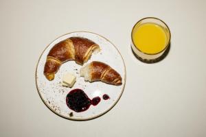 un plato de comida con pan y un vaso de zumo de naranja en Riders Hotel, en Laax