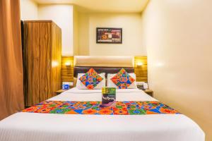 a hotel room with a bed with a colorful bedspread at FabHotel Liwa International in Mumbai