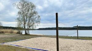 een volleybalnet in het zand naast een meer bij DWA DOMKI BORSK in Borsk