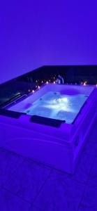 a large bath tub with purple lighting in a room at Zen in loft in Embry
