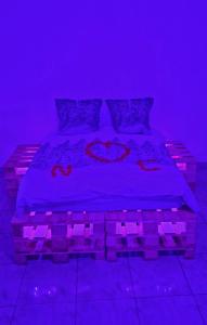 a bedroom with a bed with purple lights on it at Zen in loft in Embry