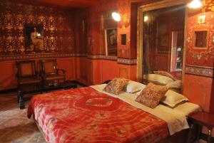 a bedroom with a large bed with red walls at Bhairon villas in Bikaner
