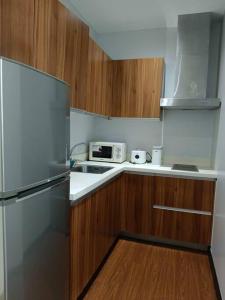 een kleine keuken met een koelkast en een magnetron bij Gramercy Residences Sunset View Condo 1 Bedroom Flat in Manilla