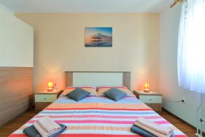 um quarto com uma cama grande e 2 candeeiros em Apartments Milka 2074 em Poreč