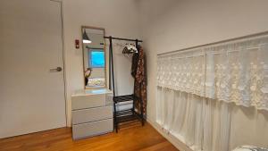 a room with a mirror and a dresser and a window at Guesthouse The Kims in Seoul