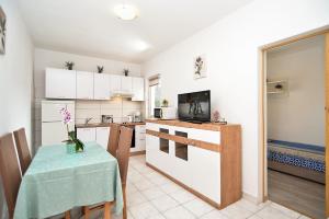 a kitchen with a table and a kitchen with white cabinets at Apartments Milka 2074 in Poreč