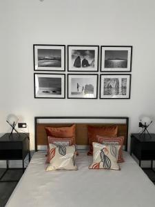 ein Schlafzimmer mit einem Bett mit vier Bildern an der Wand in der Unterkunft Casa800 in Capri