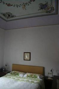 a bedroom with a bed and a painting on the wall at Villino Oliva in Pomonte