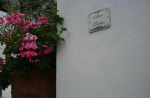 a sign on a wall with flowers on a wall at Villino Oliva in Pomonte