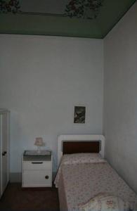 a small bedroom with a bed and a night stand at Villino Oliva in Pomonte