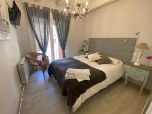 Un dormitorio con una cama grande y una lámpara de araña. en Apartamentos "Casa Abuelo Juan" en La Granja de San Ildefonso