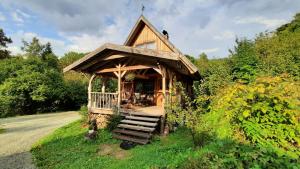 a small house with a porch on a hill at Domalek pod Złotym Kogutem in Kudowa-Zdrój