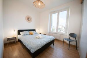 - une chambre avec un lit, une chaise et une fenêtre dans l'établissement Superbe appartement 2 pièces avec vue mer - Brest, à Brest