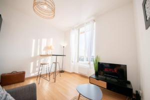 een woonkamer met een bank, een tv en een tafel bij Superbe appartement 2 pièces avec vue mer - Brest in Brest