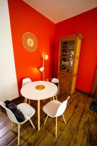 stół i krzesła w pokoju z czerwonymi ścianami w obiekcie Gîte La Petite Ourse w mieście Andenne