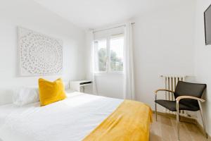 a white bedroom with a yellow bed and a chair at Private room in renovated apartment - Tram 1 min walk in Nice