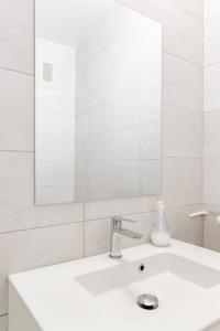 Baño blanco con lavabo y espejo en Private room in renovated apartment - Tram 1 min walk en Niza