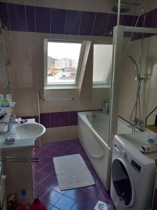 a bathroom with a sink and a washing machine at Apartment 075 in Tuzla