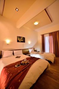 two beds in a hotel room with a tray on the bed at Byzantion Hotel in Mystras