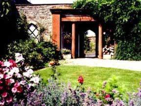ein Garten mit Blumen vor einem Gebäude in der Unterkunft The White House Guest House in Penrith + 17 Fotos
