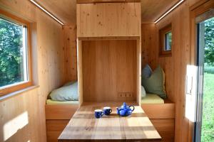 a tiny house with a table and two beds at Villa Larix-Das Vollholzhaus direkt am Berzdorfer See in Görlitz