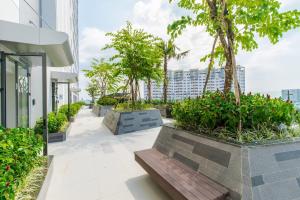 ein Gehweg mit Bänken und Bäumen auf einem Gebäude in der Unterkunft Summerset Saigon - The Perfect Place to Live in District 1 in Ho-Chi-Minh-Stadt