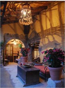una sala de estar con una lámpara de araña y flores en un edificio en El Callejon De Andrese en Loarre