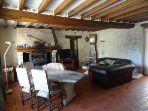 Villa de campagne avec piscine في Beaulieu-sur-Loire: غرفة معيشة مع طاولة وأريكة