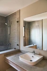 een badkamer met een wastafel, een douche en een spiegel bij Dar Meha in Marrakesh