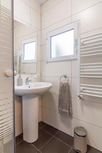 a white bathroom with a sink and a window at Apartamento. El Rincón de Cañadío in Santander