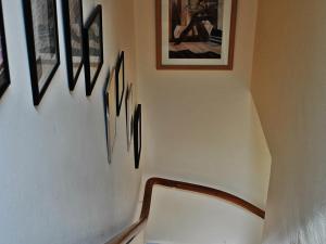 a hallway with a chair and some pictures on the wall at Heathcote B&B in Inverness