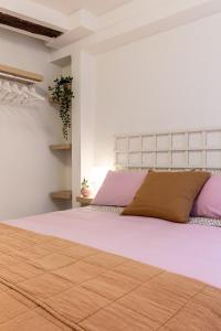 a bedroom with a large bed with pink and purple pillows at Apartamento. El Rincón de Cañadío in Santander