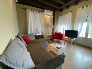 a living room with a couch and a tv at Refitolería Apartamentos in Segovia