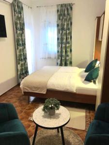 sypialnia z łóżkiem, stołem i kanapą w obiekcie Guest House Navetta 2 w Fažanie