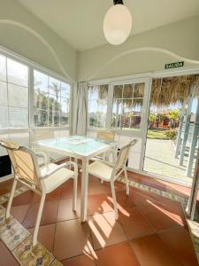 a dining room with a white table and chairs at ON Family Playa de Doñana in Matalascañas