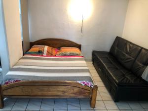 a bed and a couch in a room at à pied dans l eau écolo 97434 in L'Ermitage-Les-Bains