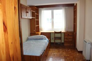 a small room with a bed and a desk and a window at Vibes Coruña-Finisterre 288 in A Coruña